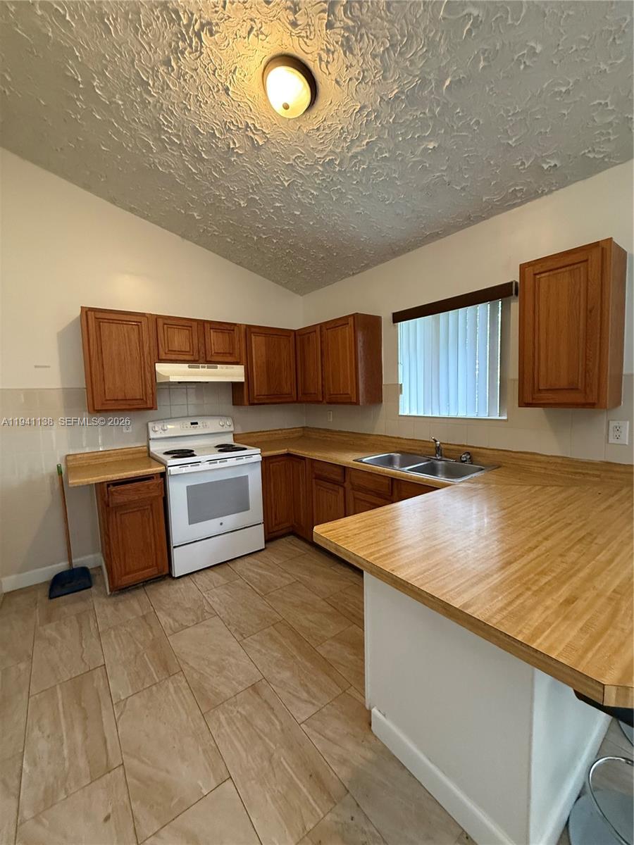 13628 Southwest 287th Lane Homestead, FL 33033 - Photo 2 of 17 a kitchen with stainless steel appliances granite countertop a sink counter space cabinets and a stove