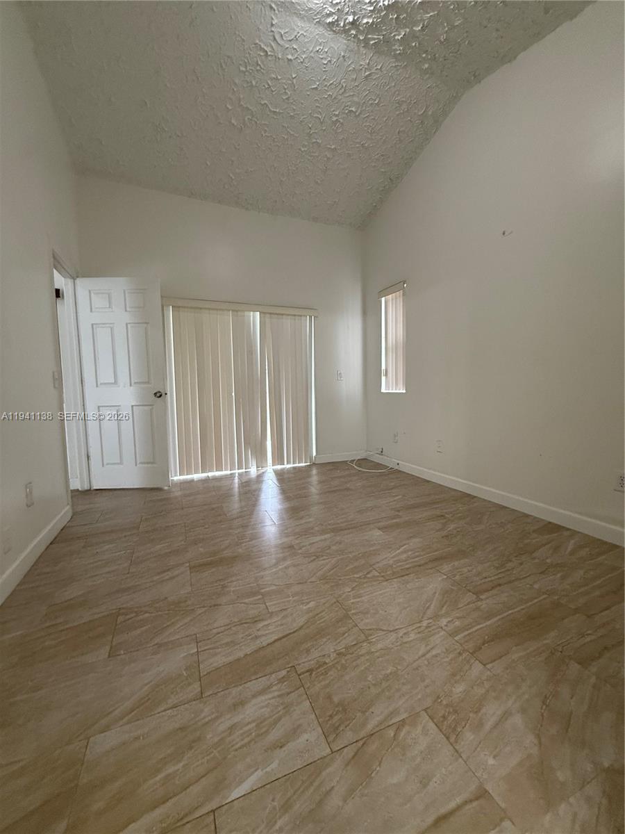 13628 Southwest 287th Lane Homestead, FL 33033 - Photo 6 of 17 a view of an empty room with wooden floor and a window