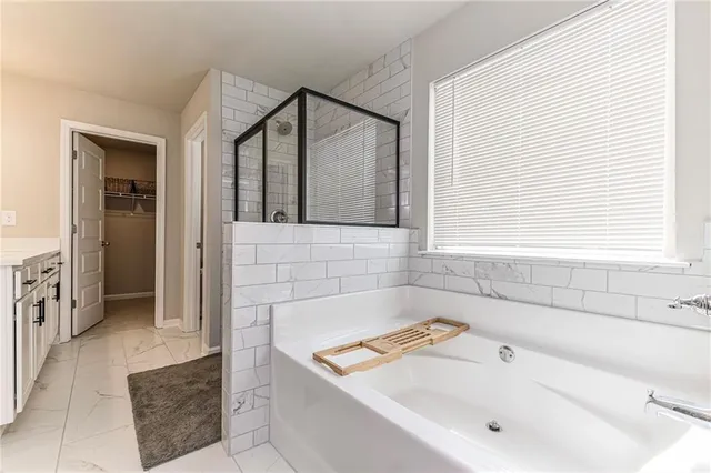 a bathroom with a tub a sink and a window