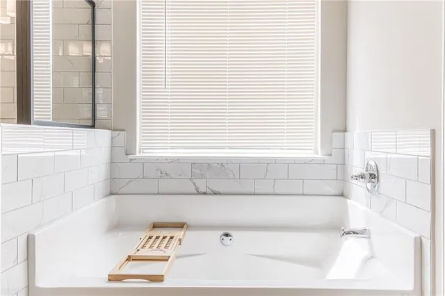 a bath tub sitting in a bathroom next to a window