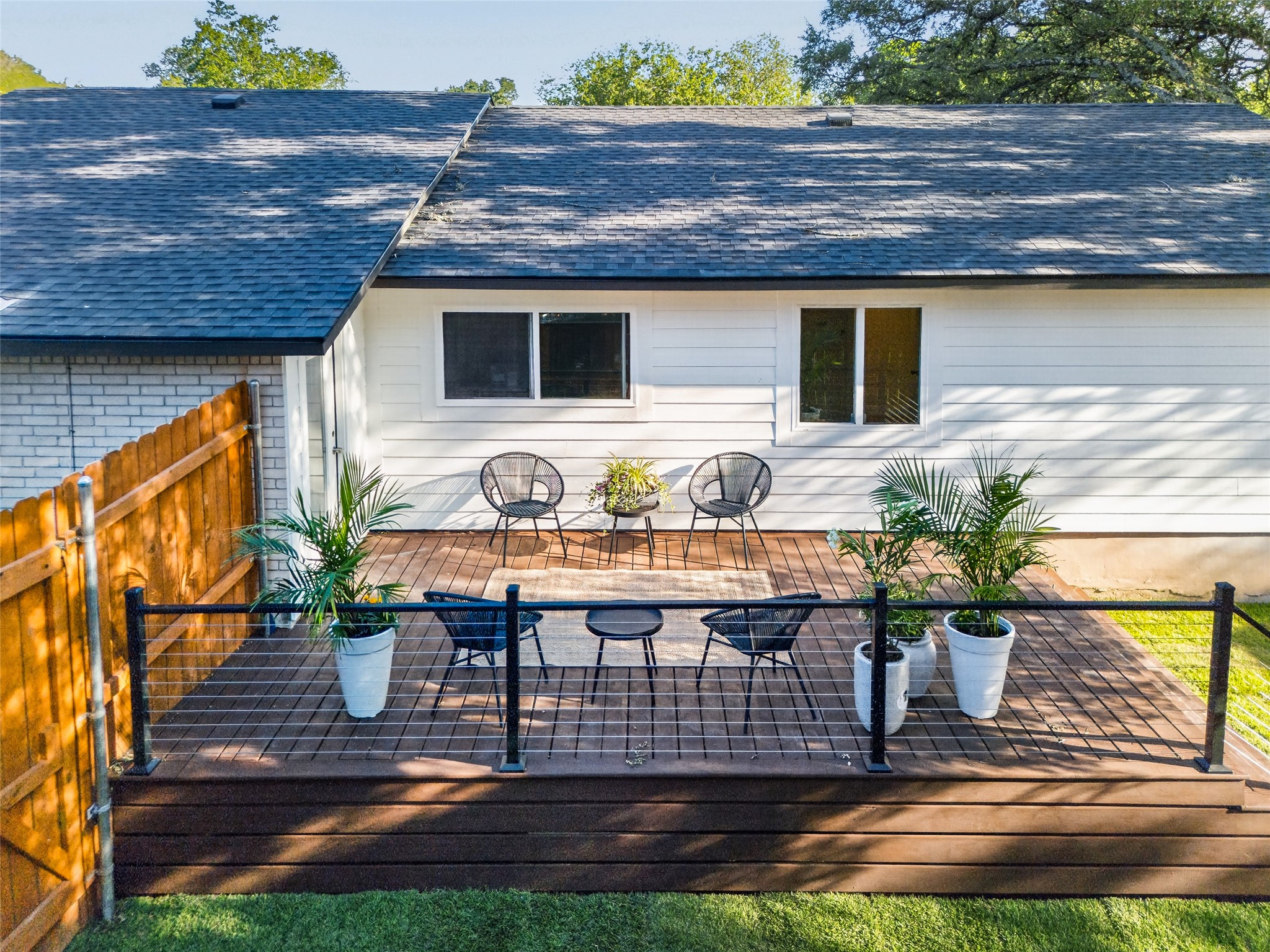6806 Rearden Road Austin, TX 78745 - Photo 27 of 28 Expansive wood-finish deck featuring a cable railing system, composite decking, and a white clapboard exterior