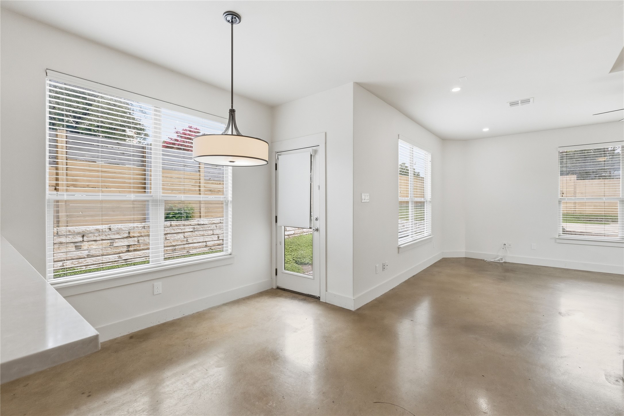 4124 Valley View Road, Unit 4A & 4B Austin, TX 78704 - Photo 6 of 40 Natural light floods this room, highlighting the sleek concrete flooring and contemporary pendant lighting.