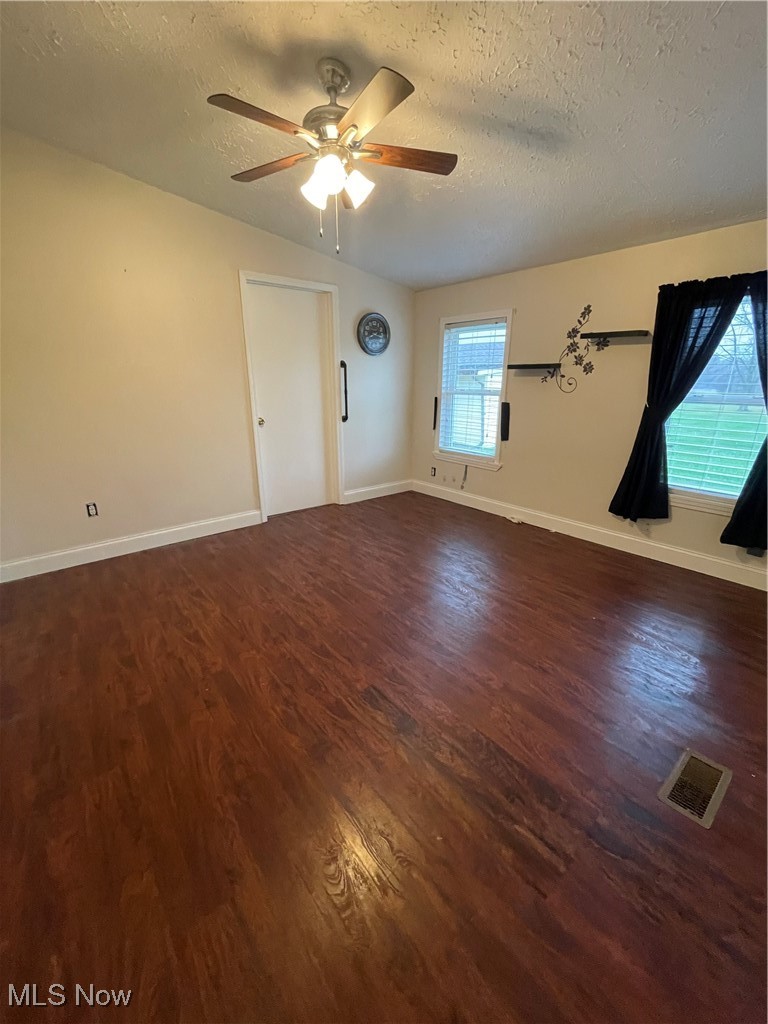 9945 Quarry Road Amherst, OH 44001 - Photo 13 of 30 Unfurnished room featuring ceiling fan, dark hardwood / wood-style flooring, and a textured ceiling