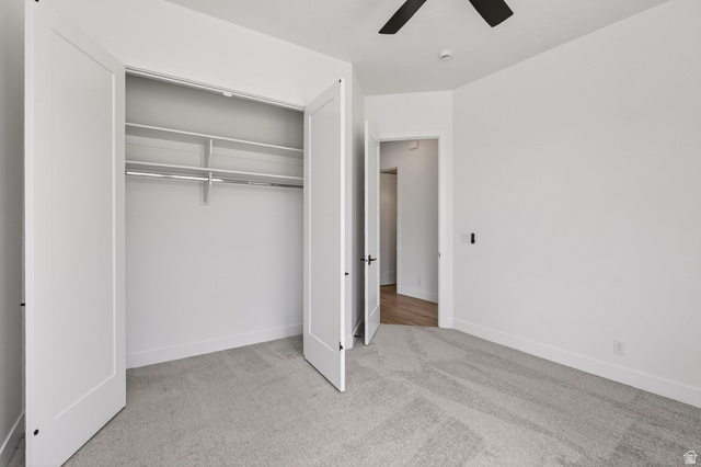 2862 South Mountain Rnch Road Cedar City, UT 84720 - Photo 37 of 64 Bedroom featuring light gray carpet, white walls, a ceiling fan with black blades, and a double-door closet with shelving and a hanging rod