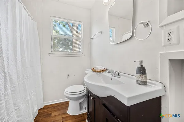 a bathroom with a sink toilet and a mirror