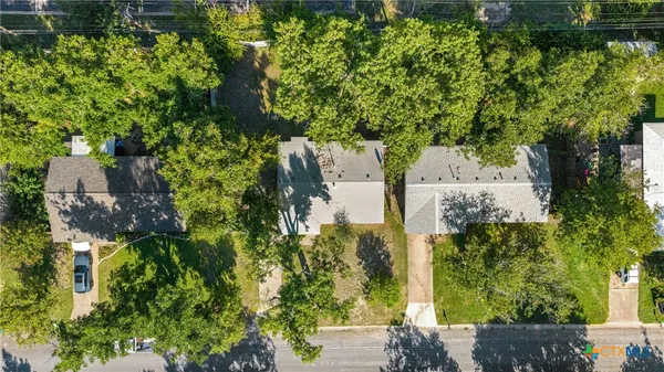 an aerial view of residential house with outdoor space and trees all around