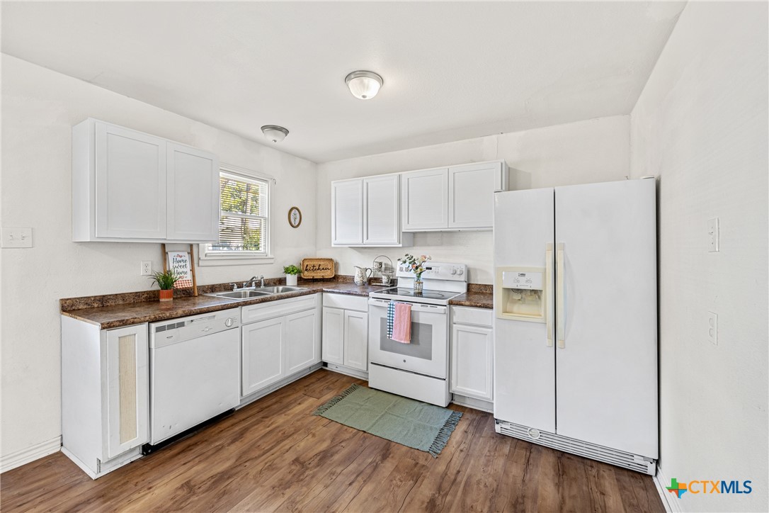13 North 41st Street Temple, TX 76504 - Photo 6 of 20 a kitchen with sink cabinets and wooden floor