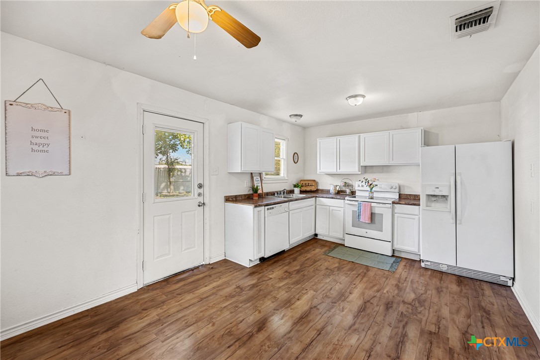 13 North 41st Street Temple, TX 76504 - Photo 7 of 20 a kitchen with white cabinets and white appliances