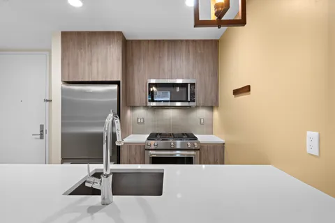 a kitchen with kitchen island a stove and a refrigerator with wooden floor