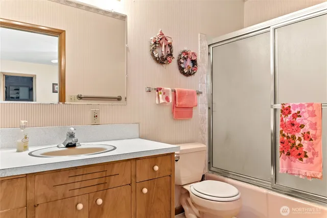 a bathroom with a sink mirror vanity and toilet