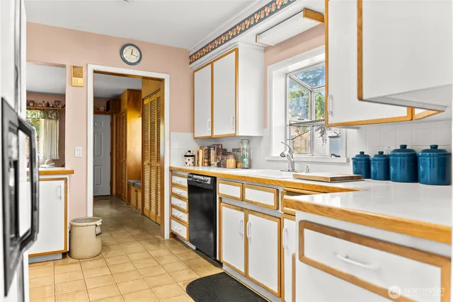 a large kitchen with a window and stainless steel appliances