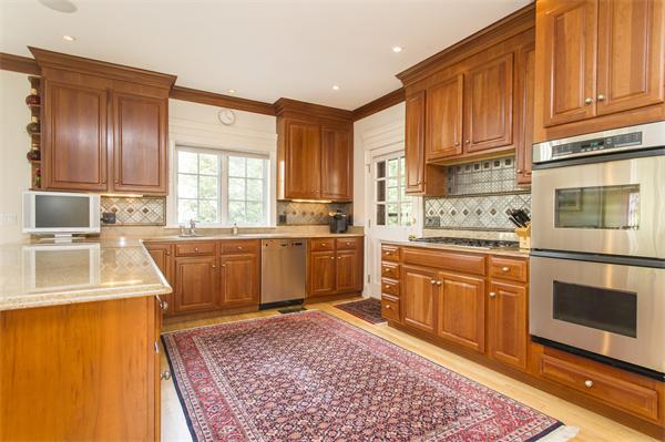 22 Chestnut Hill Road Newton, MA 02467 - Photo 7 of 30 a kitchen with stainless steel appliances granite countertop a sink a stove a refrigerator cabinets and a center island