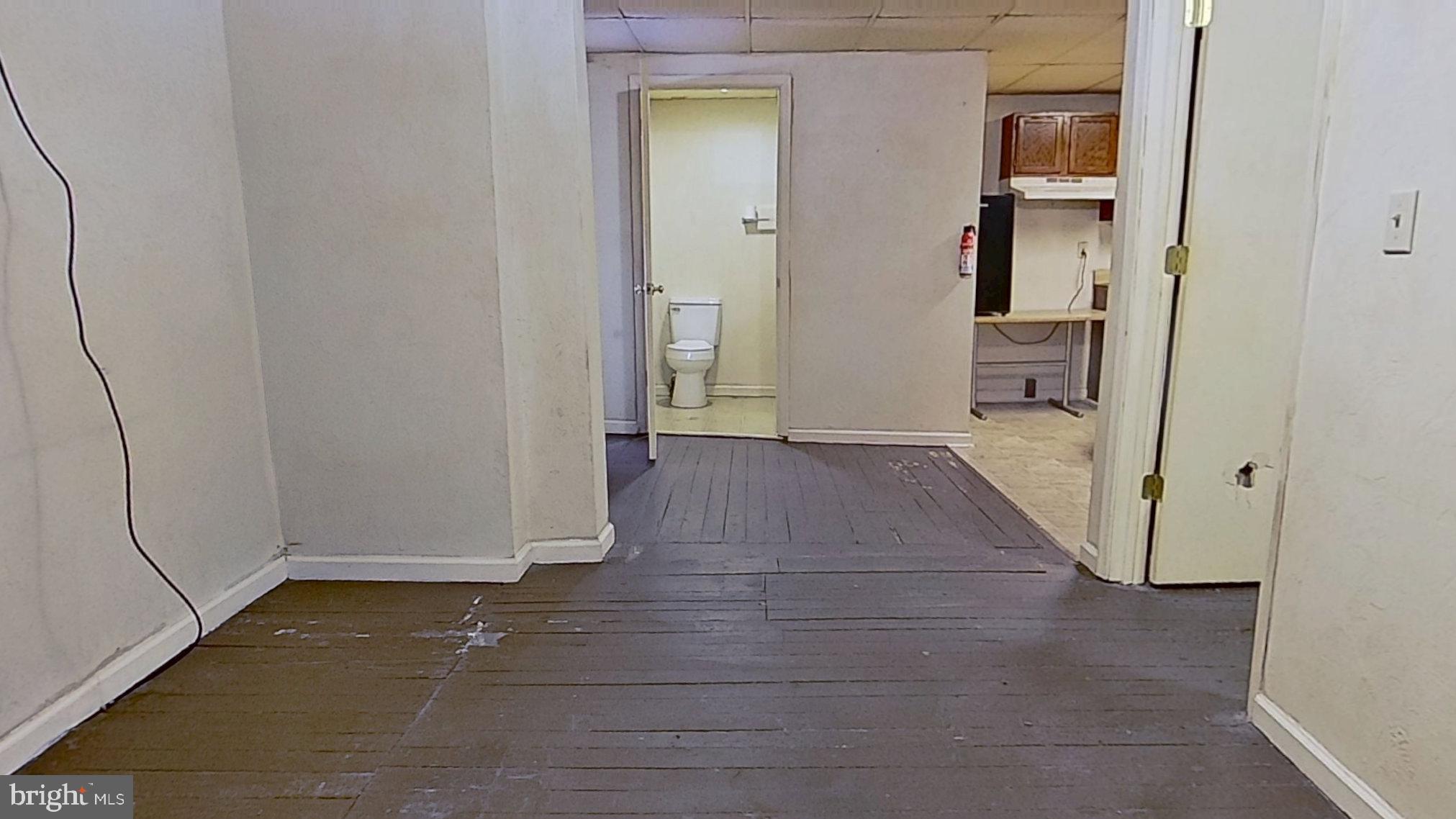 128 South Main Street, Unit 4 Spring Grove, PA 17362 - Photo 3 of 4 an empty room with wooden floor and a bathroom