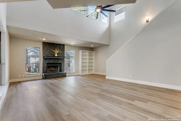 a view of empty room with wooden floor and fireplace