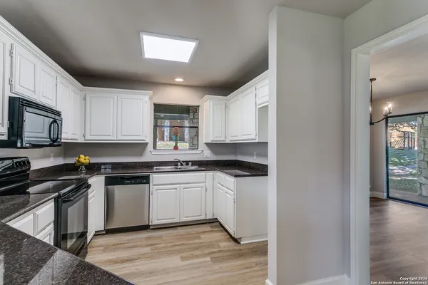 a kitchen with stainless steel appliances granite countertop a stove top oven a sink dishwasher and a microwave oven on the blue kitchen countertops
