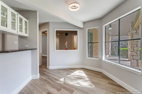 a view of empty room with window and wooden floor