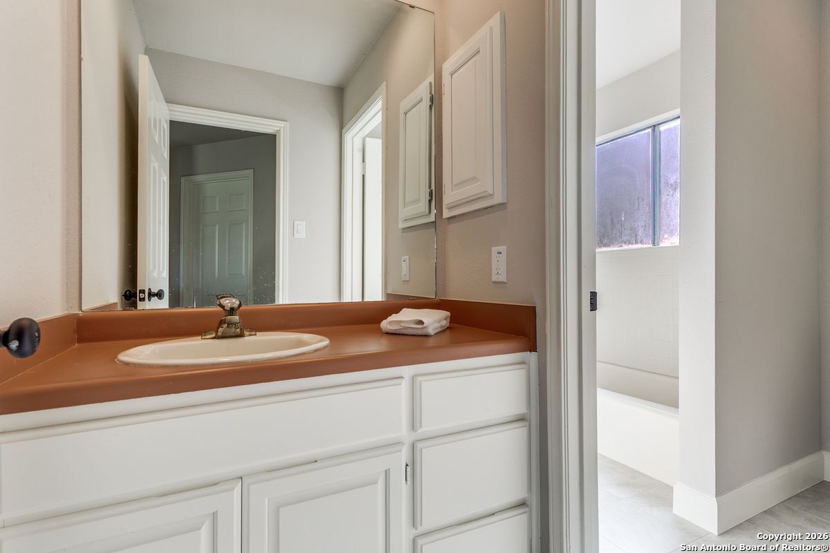 9380 Braun Road, Unit 501B San Antonio, TX 78254 - Photo 24 of 29 a en suite bathroom with a granite countertop sink and a mirror