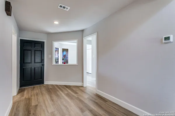 an empty room with closet and windows