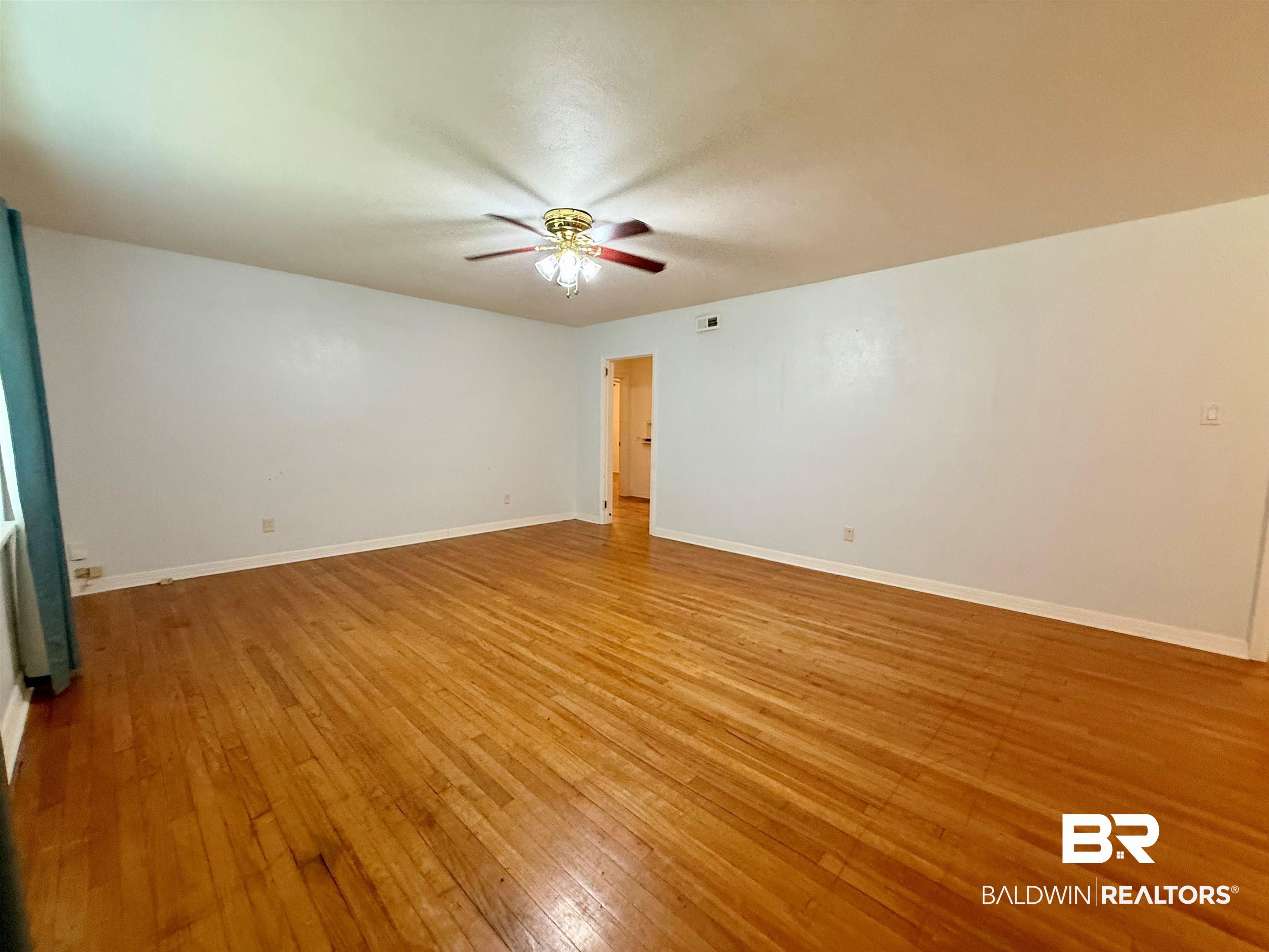 403 Sutherland Drive Mobile, AL 36611 - Photo 8 of 8 Spare room featuring a ceiling fan, light wood-style flooring, and baseboards