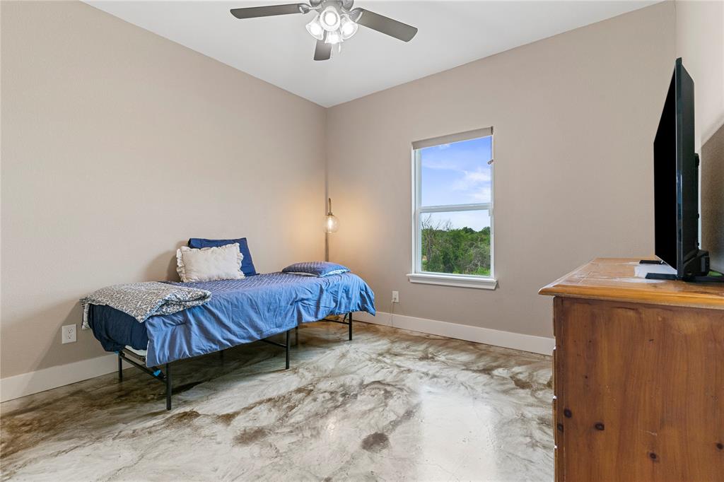 139 Kriston Lane Springtown, TX 76082 - Photo 14 of 39 Neutral wall paint with white trim, a double-hung window, and a ceiling fan with integrated lighting
