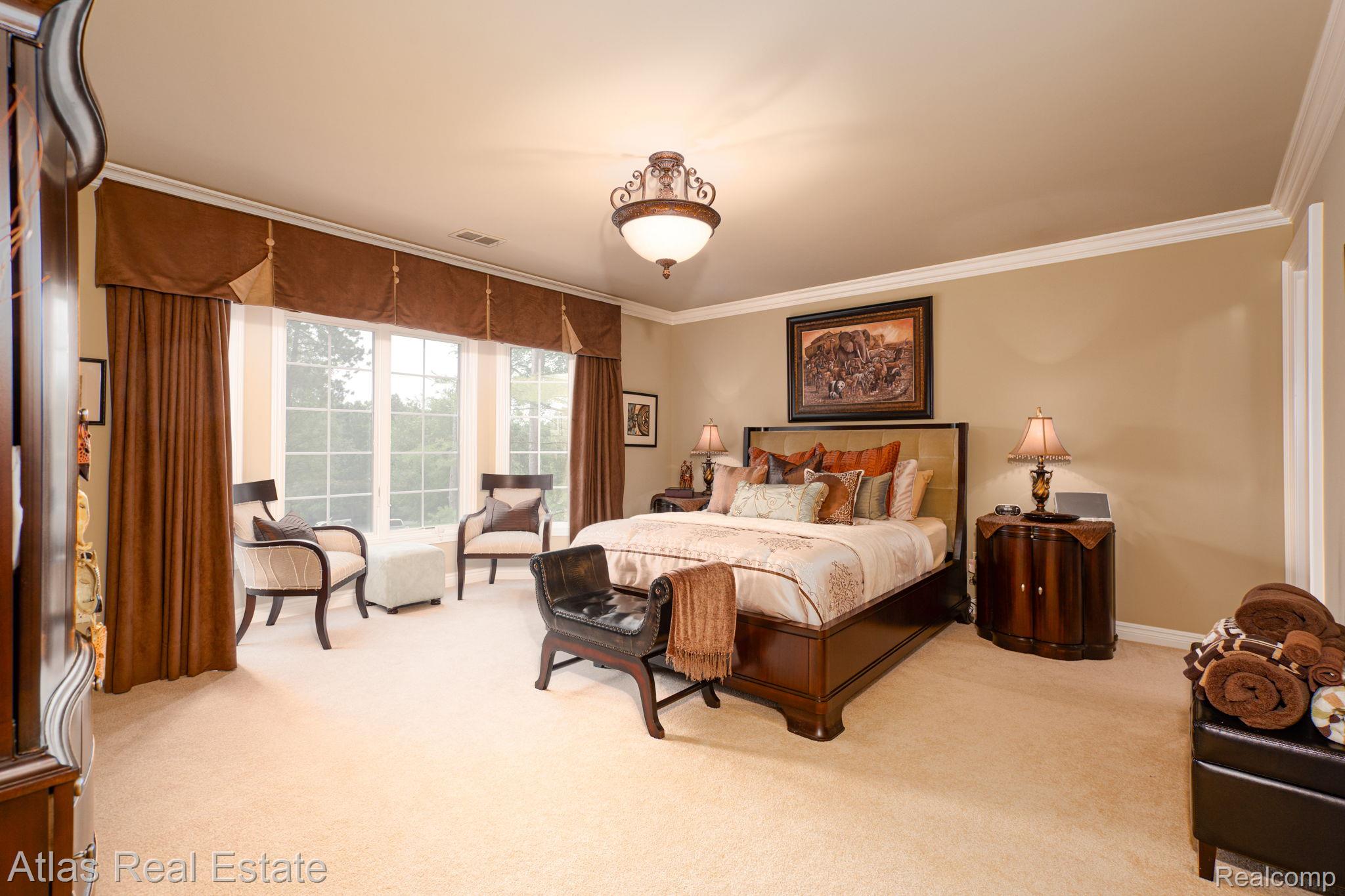 10380 South State Road Goodrich, MI 48438 - Photo 53 of 87 Spacious room featuring a multi-pane window with custom valances and drapery, a central ceiling fixture, crown molding, and neutral-toned carpeting
