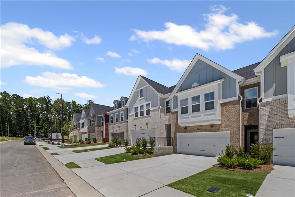 a front view of a house with a garden and trees