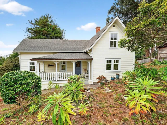 a front view of house with yard and trees around