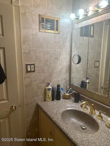 a bathroom with a granite countertop sink a mirror a vanity and shower