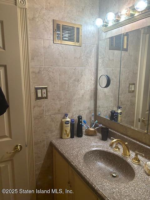 45 Daffodil Court Staten Island, NY 10312 - Photo 22 of 37 a bathroom with a granite countertop sink a mirror a vanity and shower