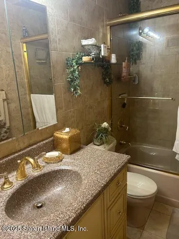 a bathroom with a granite countertop sink a toilet and shower