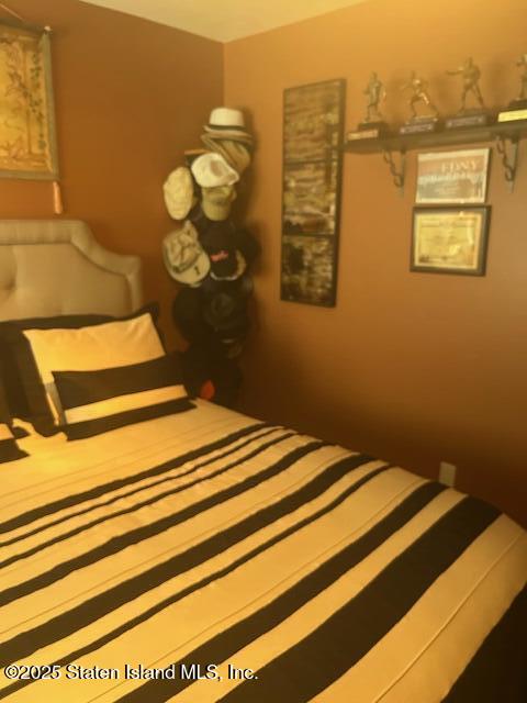 45 Daffodil Court Staten Island, NY 10312 - Photo 29 of 37 a bedroom with a bed and wooden floor