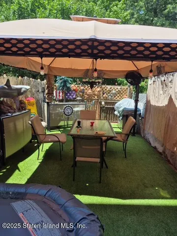a view of a chairs and table in patio with a barbeque