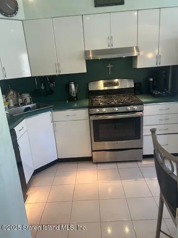 a kitchen with granite countertop a stove a sink a microwave and cabinets