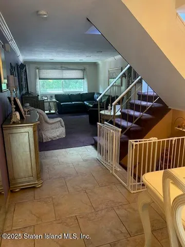 a view of a livingroom with furniture stairs and a floor to ceiling window