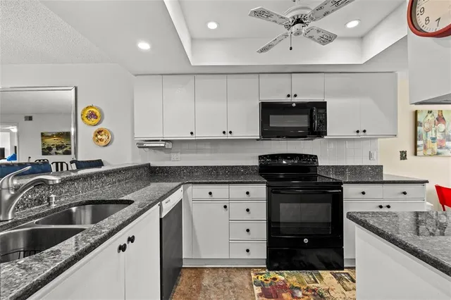 a kitchen with granite countertop a sink and cabinets