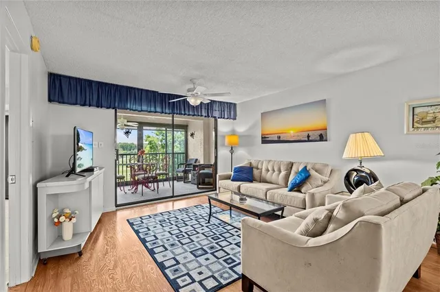 a living room with furniture a flat screen tv and a floor to ceiling window