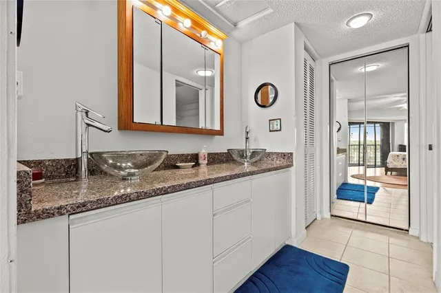 a bathroom with a granite countertop sink and a mirror