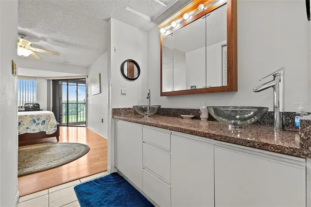 a en suite bathroom with a granite countertop sink and a mirror