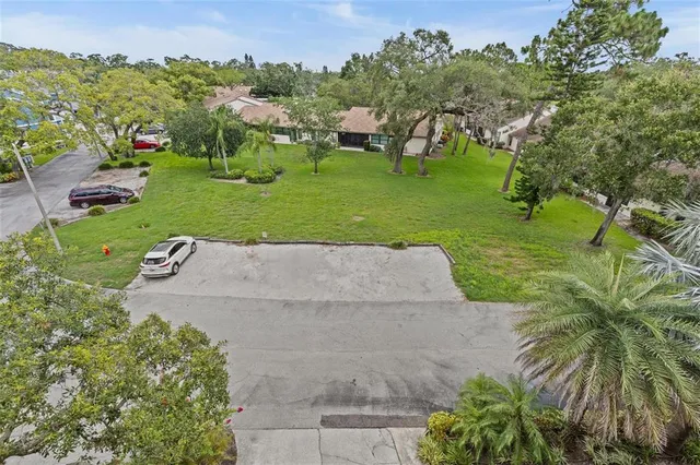 an aerial view of a house with a yard and lake view