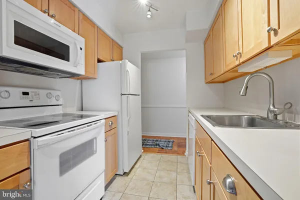 a kitchen with stainless steel appliances granite countertop a sink and a stove top oven with white countertops