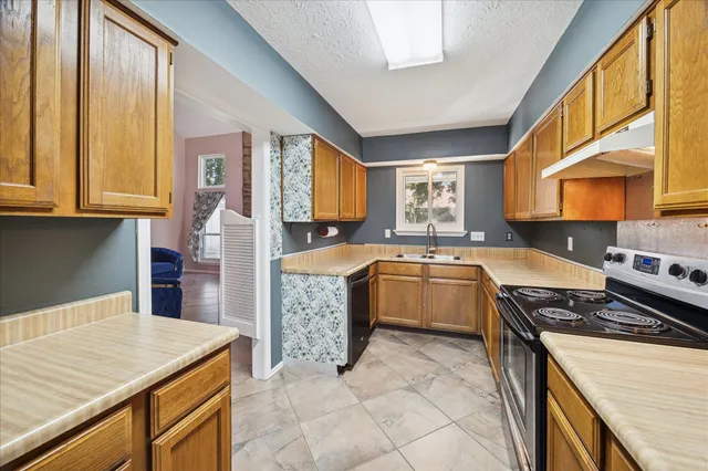 a kitchen with stainless steel appliances granite countertop a stove a sink and a microwave