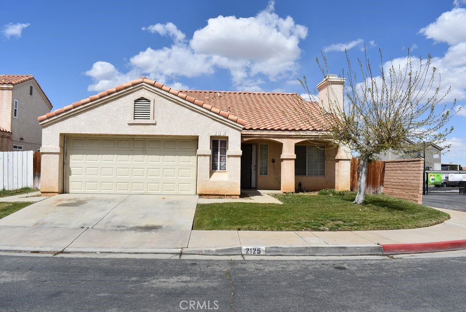 2125 Bramble Lane Palmdale, CA 93550 - Photo 1 of 28 a front view of a house with a yard and garage