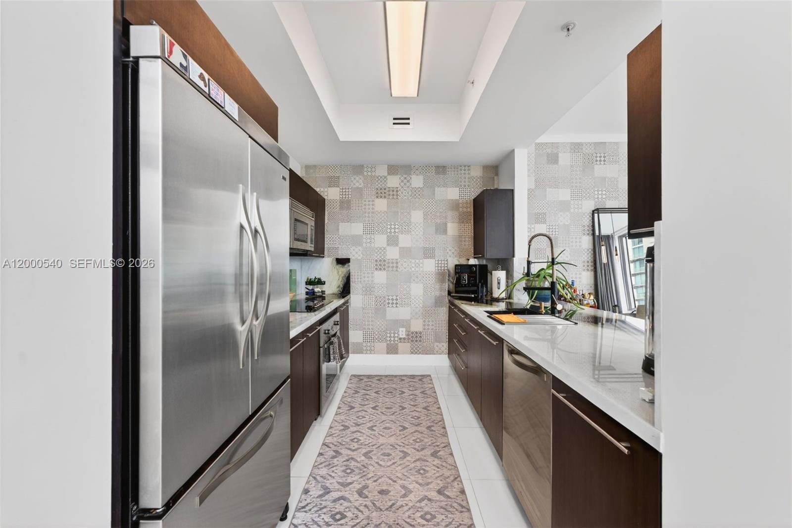 90 Southwest 3rd Street, Unit PH12 Miami, FL 33130 - Photo 17 of 40 a kitchen with stainless steel appliances granite countertop a refrigerator a sink a stove and dishwasher