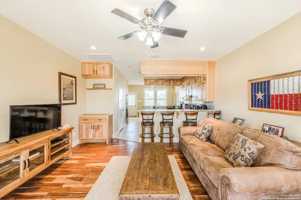 a living room with furniture a flat screen tv and a dining table