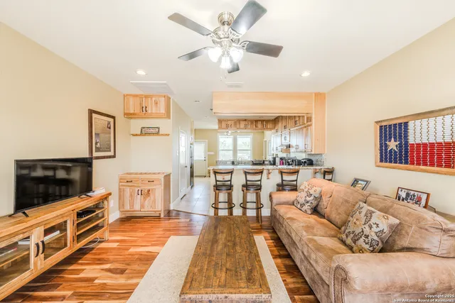 a living room with furniture a flat screen tv and a dining table