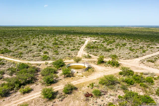 a terrace with a table and chairs under an umbrella