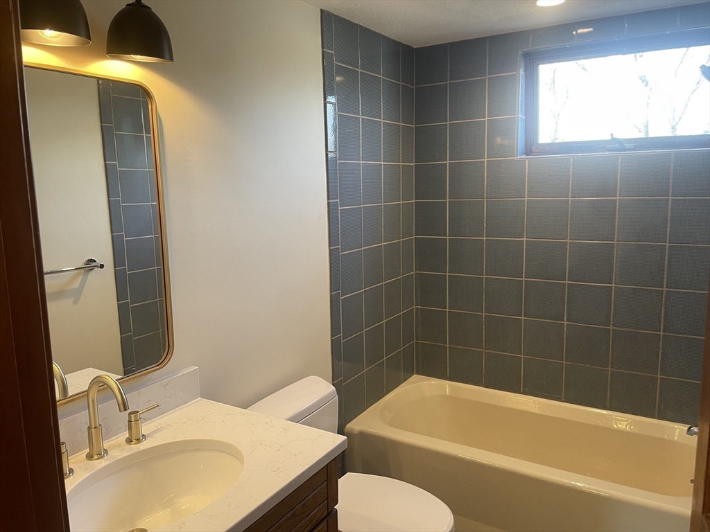 98 Rockland Street, Unit 3 Swampscott, MA 01907 - Photo 17 of 19 a bathroom with a sink mirror toilet and bathtub