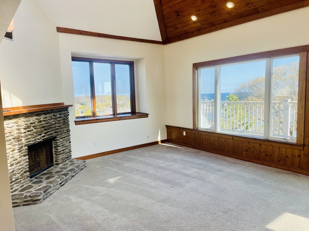 98 Rockland Street, Unit 3 Swampscott, MA 01907 - Photo 4 of 16 an empty room with windows and fireplace