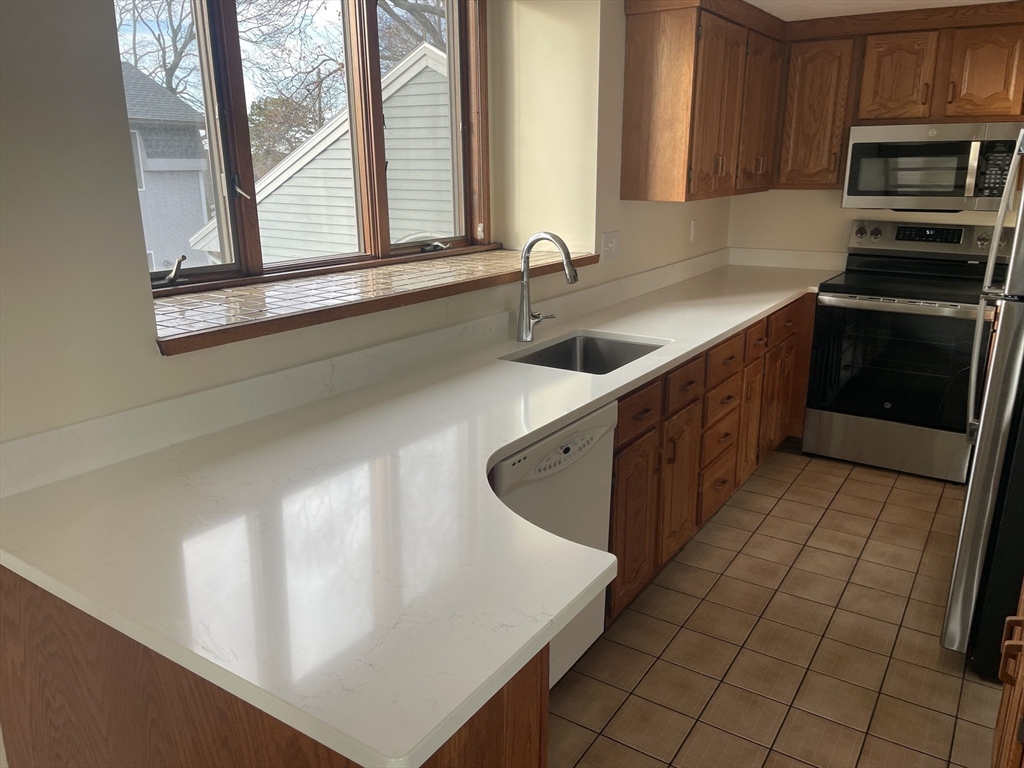 98 Rockland Street, Unit 3 Swampscott, MA 01907 - Photo 7 of 19 a kitchen with stainless steel appliances a sink stove and cabinets