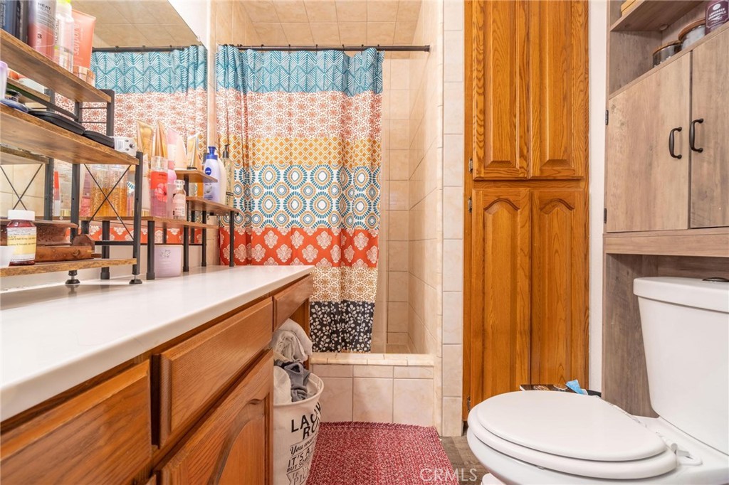 9920 Broadway Temple City, CA 91780 - Photo 16 of 26 a bathroom with a sink a toilet and shower curtain